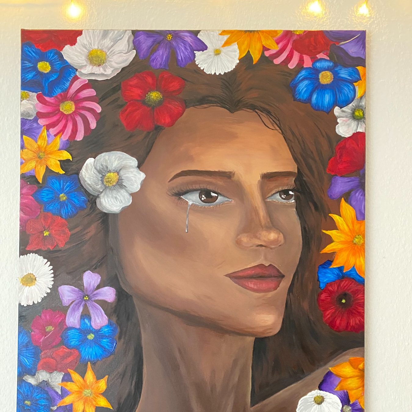 Porträt einer Frau mit Blumen im Haar, umrahmt von bunten Blumen.
